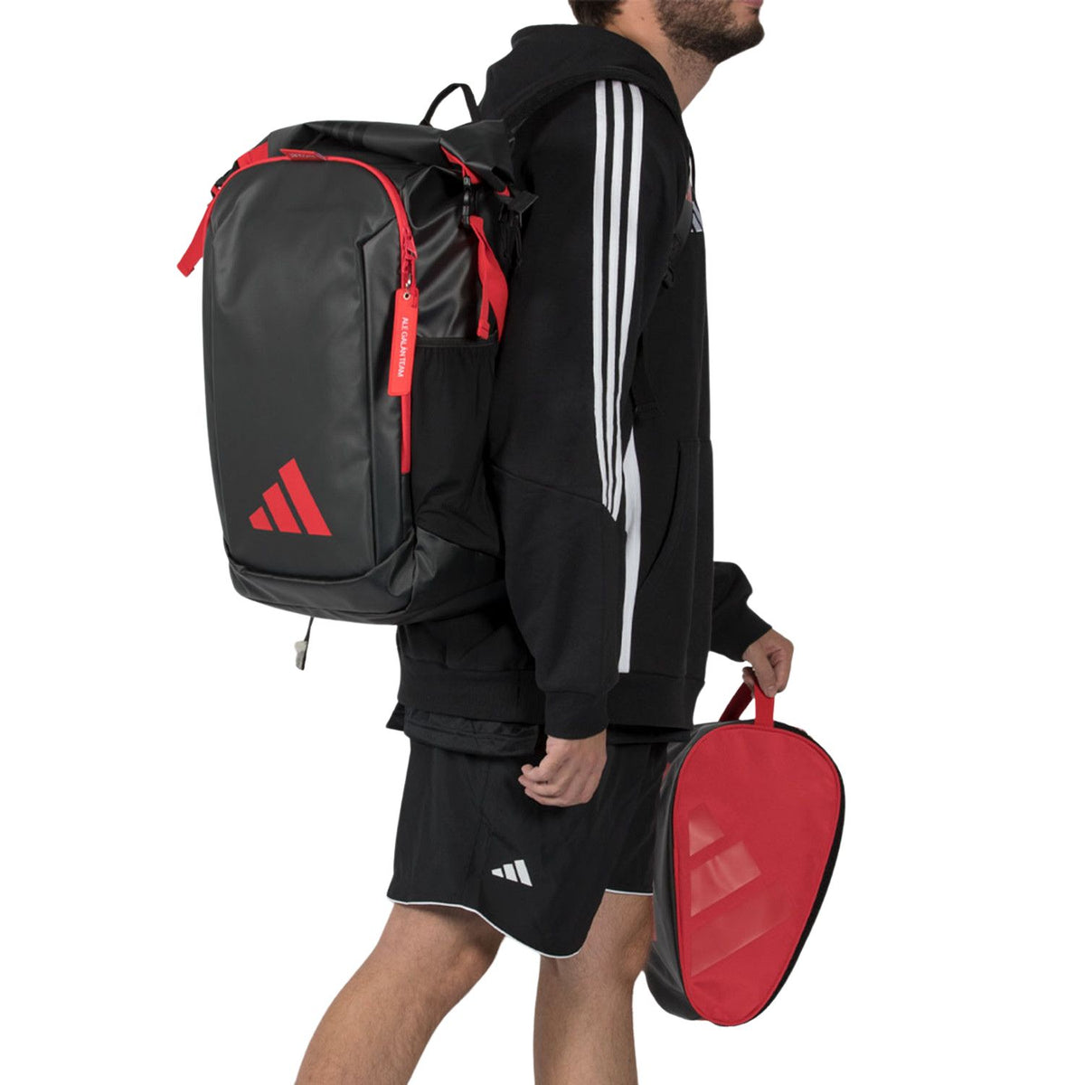 Speler draagt de zwart-rode Adidas Backpack Multigame 2026 over een schouder met rackethoes