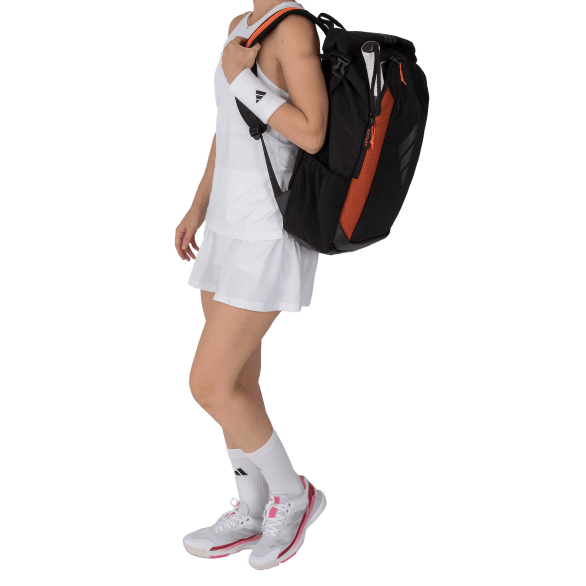 Model draagt de zwart-oranje Adidas Backpack Multigame 3.4 aan de bovenhandgreep.
