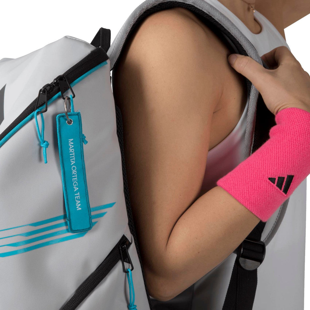 Detail van de schouderband van de witte Adidas Protour 3.4 met turquoise hanglabel.