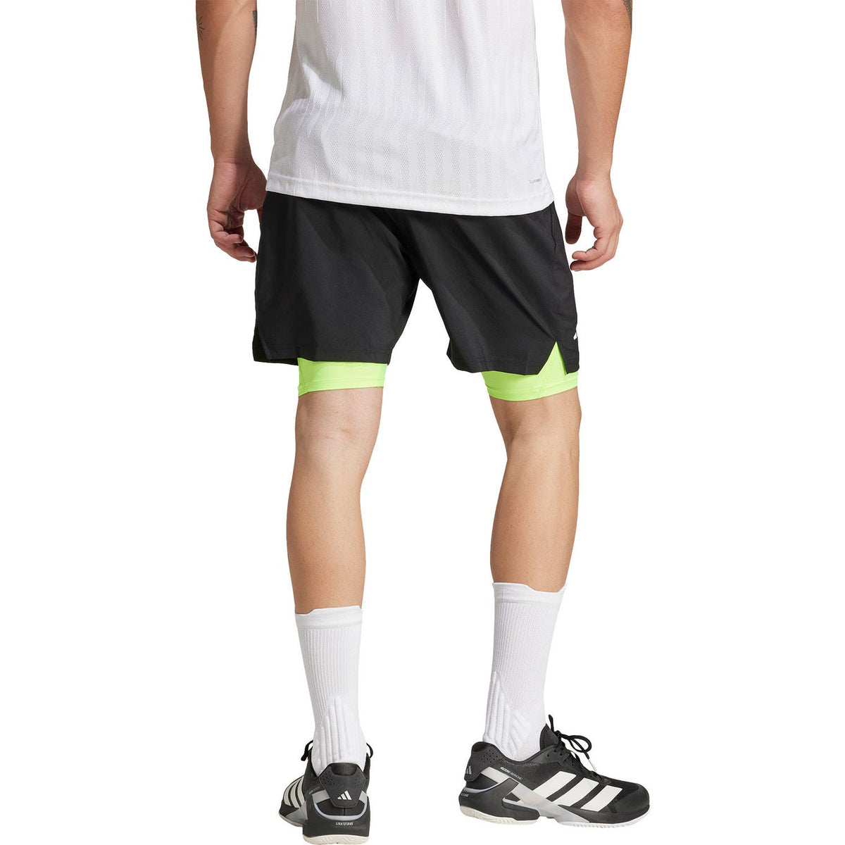 Achteraanzicht van de zwarte Adidas Club 2IN1 short met limegroene binnenbroek eronder