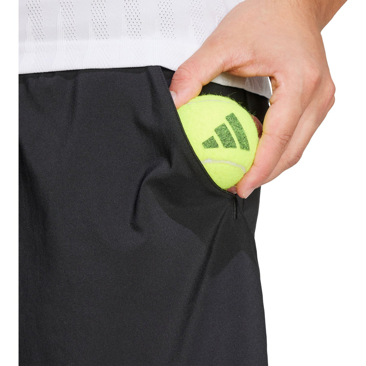 Detail van de zijzak van de zwarte Club 2IN1 short met limegroene voering en hand in de zak