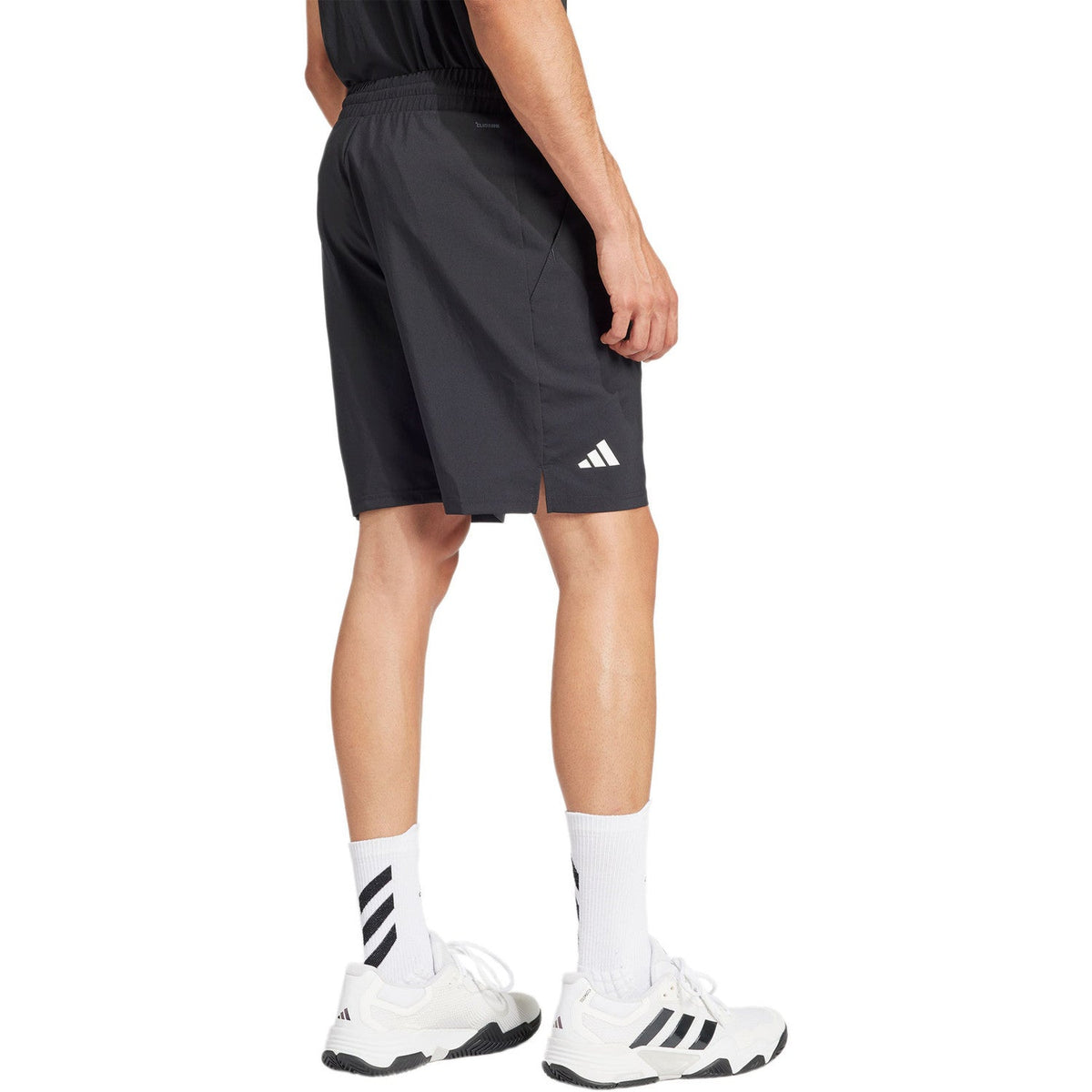 Model draagt de zwarte Adidas Club 3-Stripes short, zijaanzicht met logo op de pijp