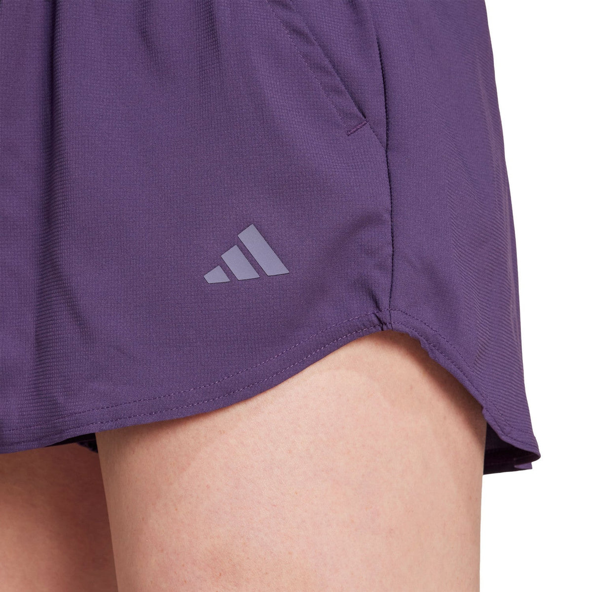 Detail van het grijze logo op de pijp van de paarse Club short