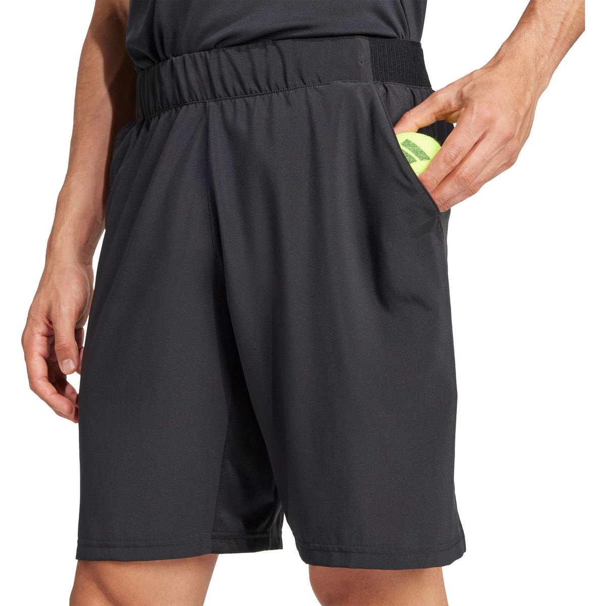 Detail van de zijzak van de zwarte Adidas Club Stretch short met een gele bal erin