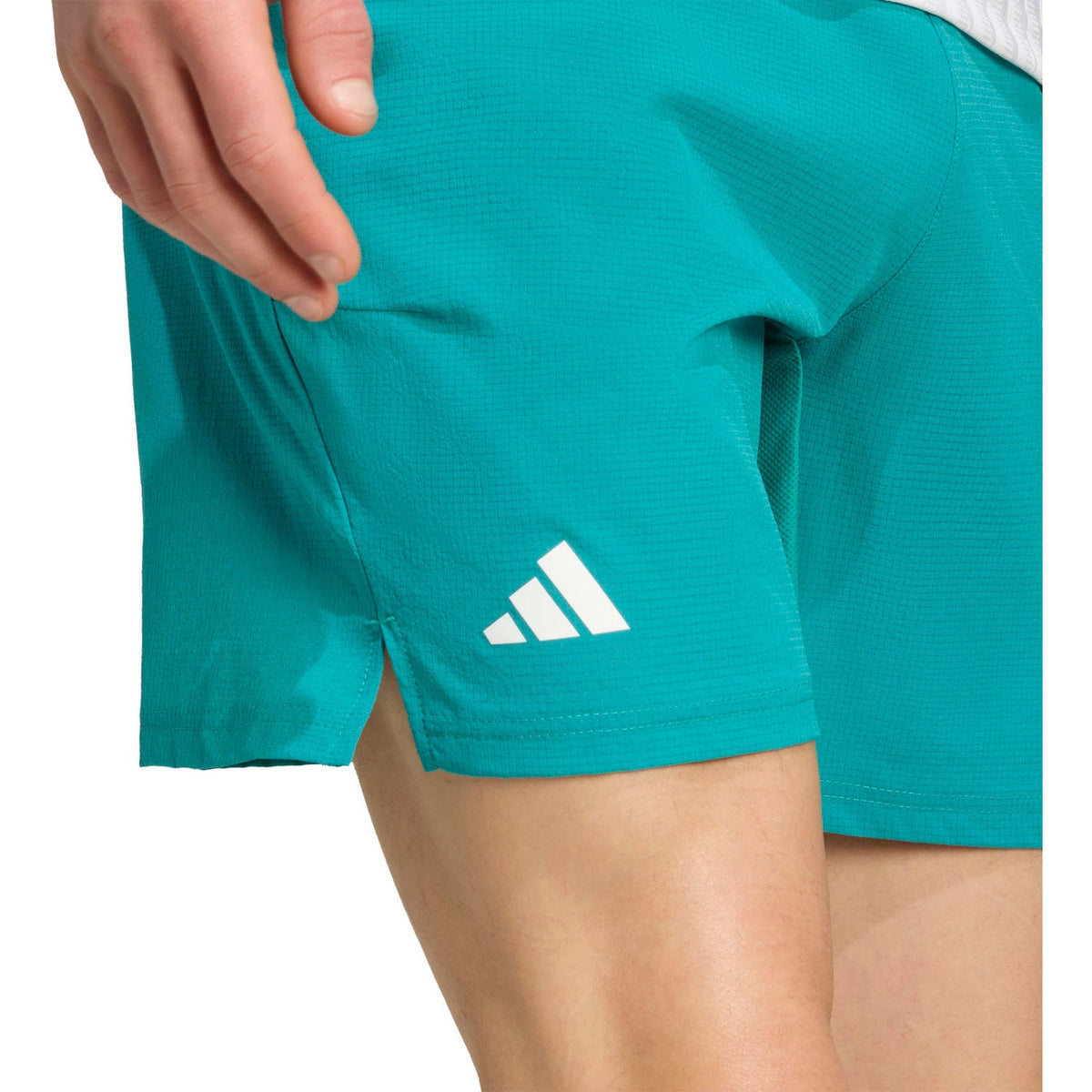 Detail van het witte adidas-logo op de pijp van de turquoise Ergo short