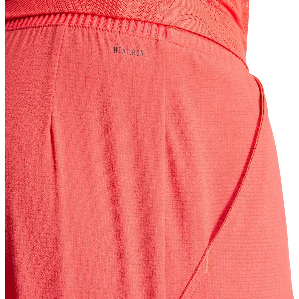 Detail van de stof en zijnaad van de koraalrode Adidas Ergo short