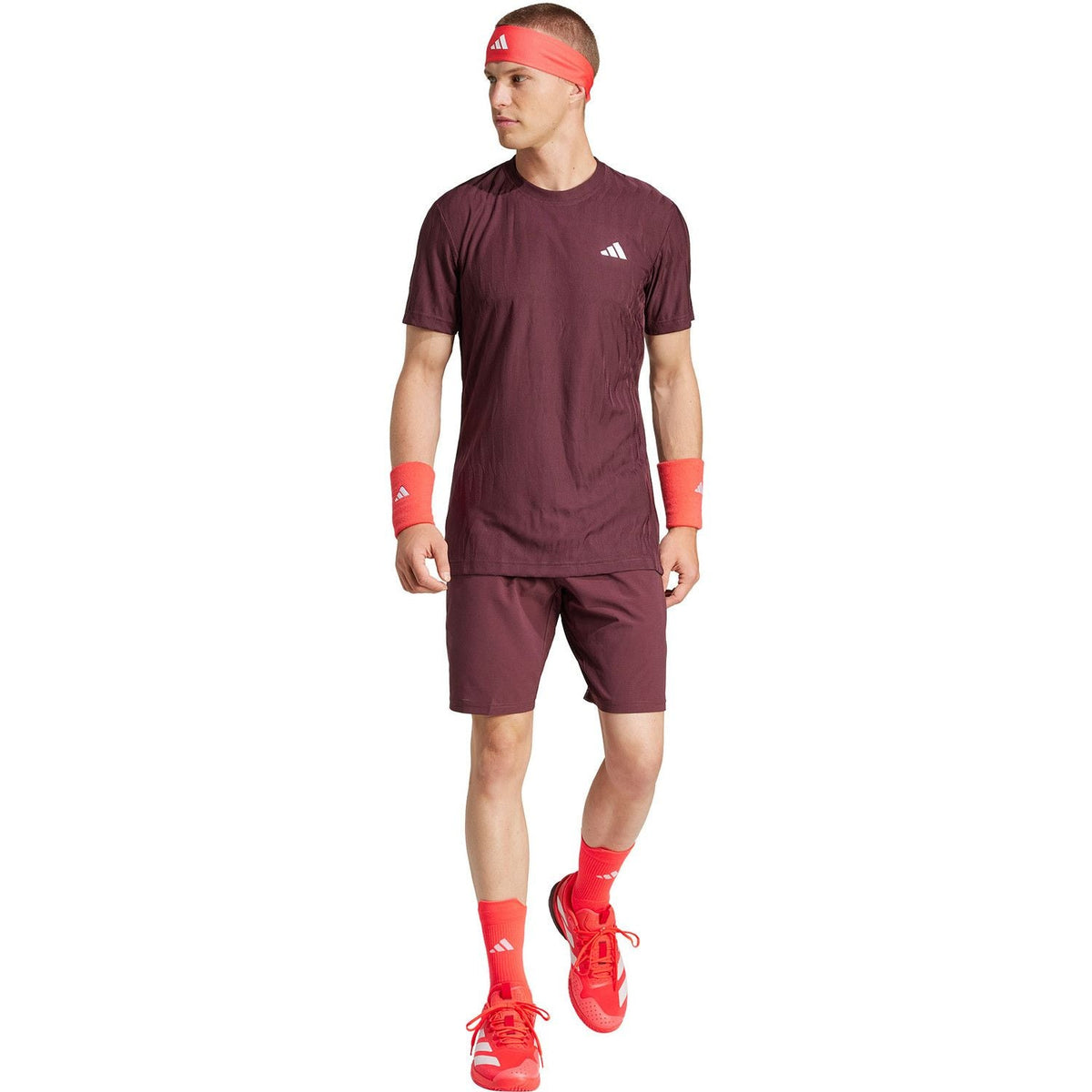Model draagt de bordeauxrode Adidas Ergo short met bijpassend shirt