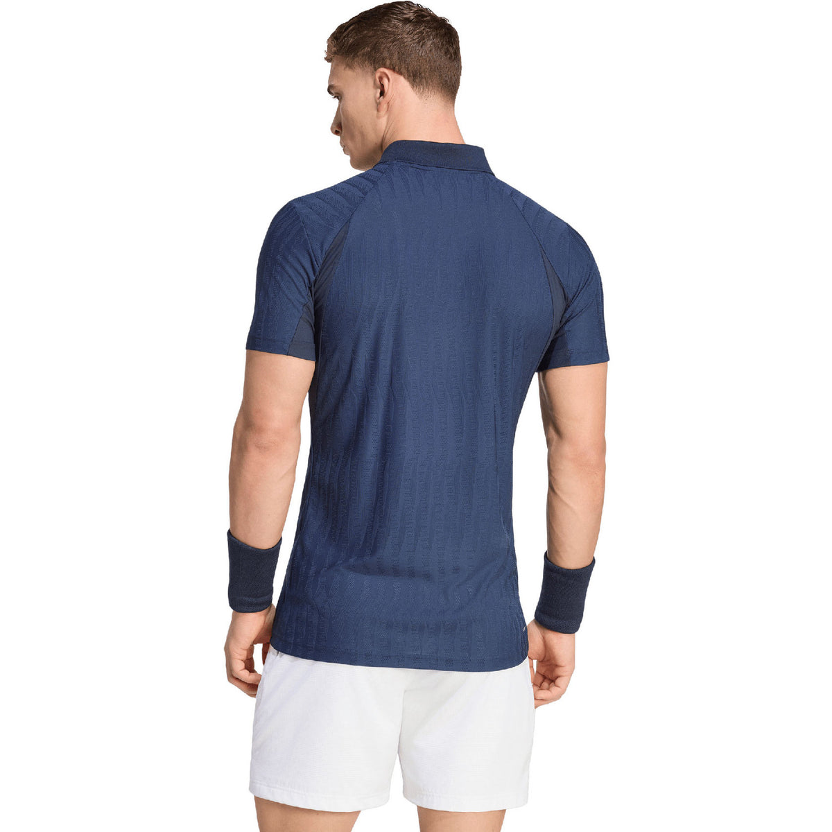 Achterzijde van de donkerblauwe Adidas Freelift polo op model