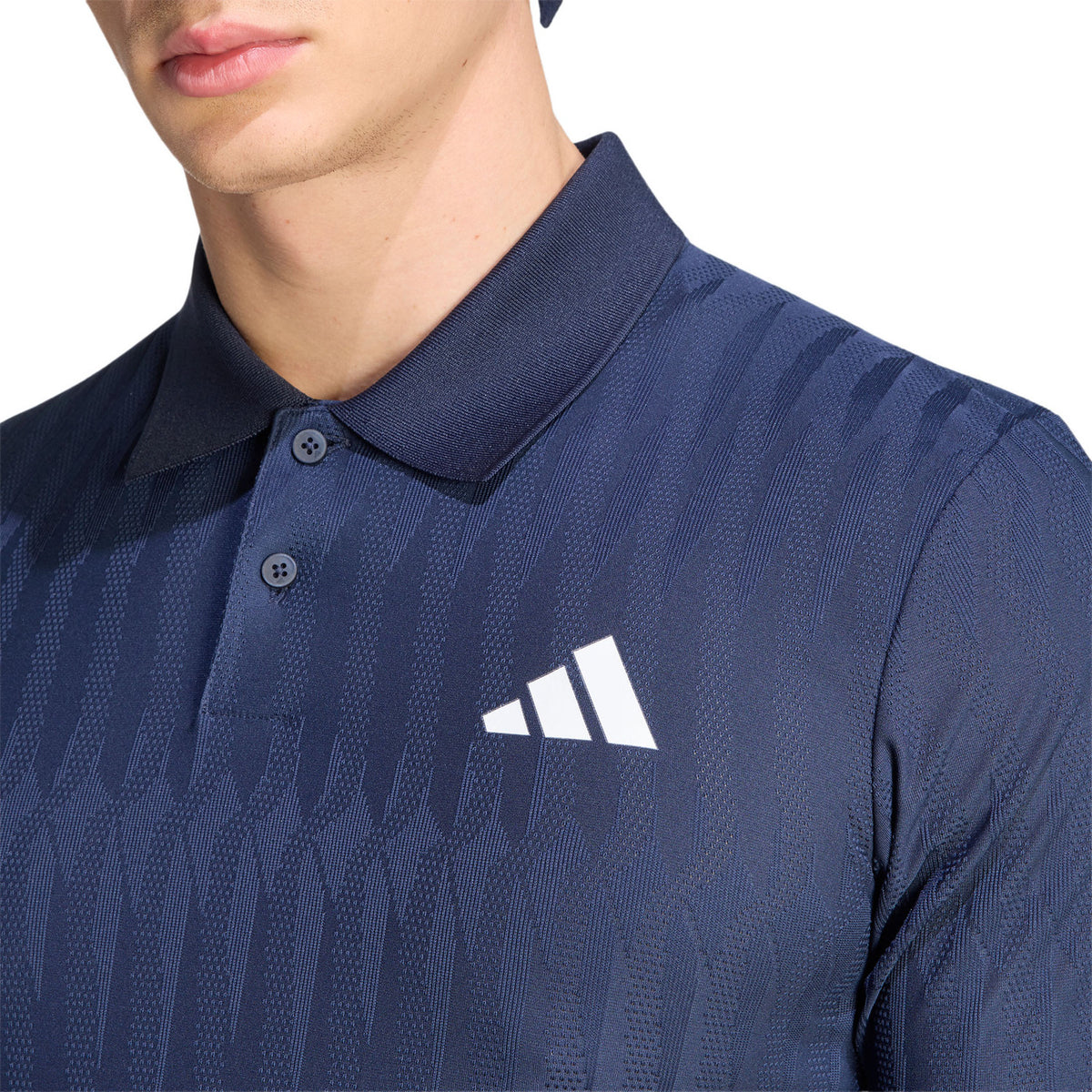 Detail van de kraag en het logo op de donkerblauwe Adidas Freelift polo