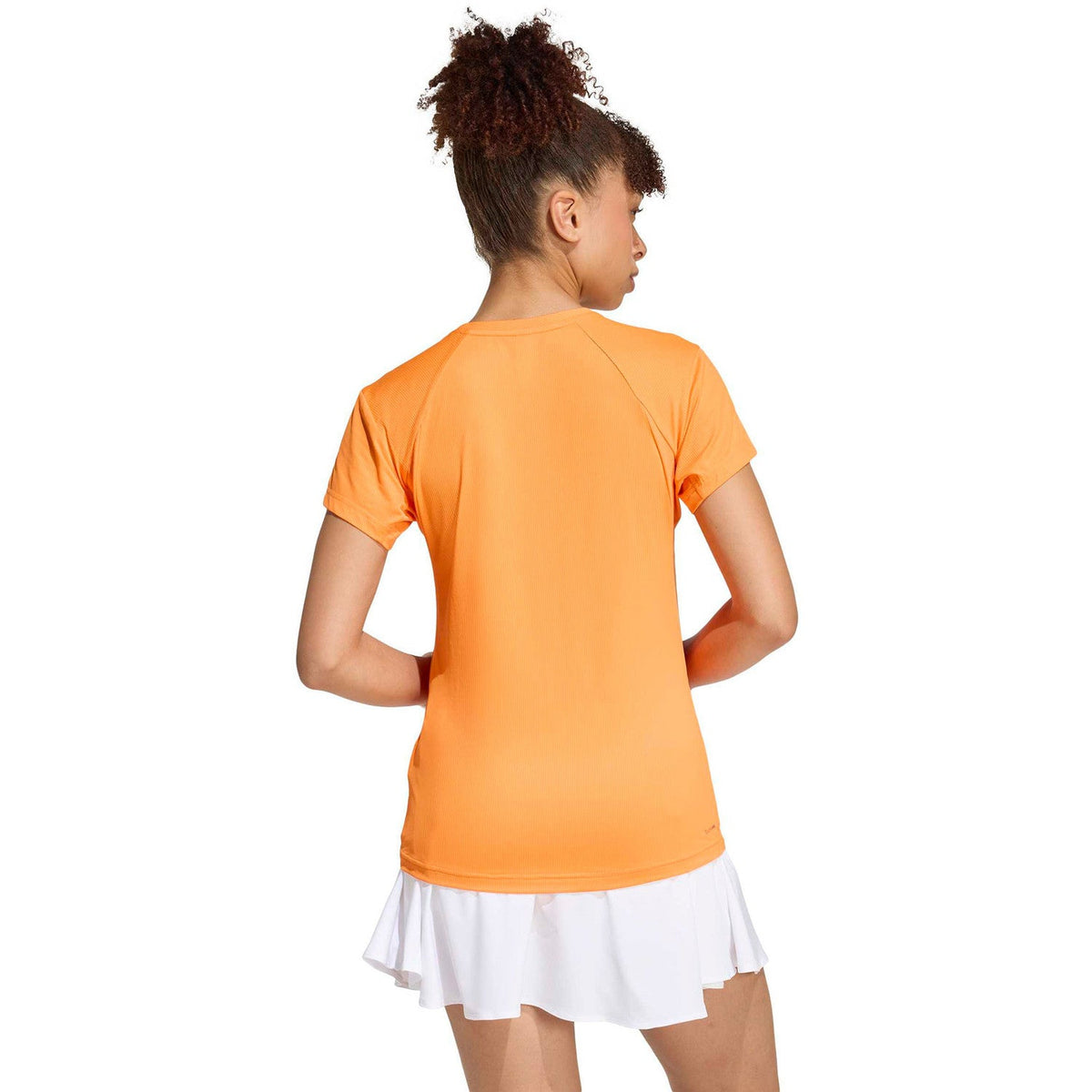 Achterzijde van het oranje Adidas Freelift T-shirt op model