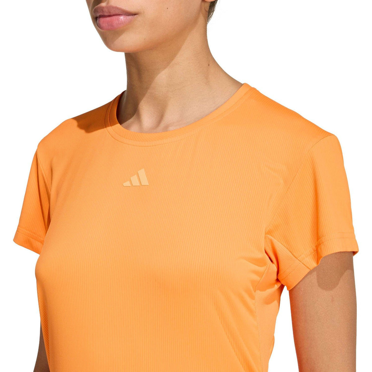 Detail van de ronde hals en het logo van het oranje Freelift T-shirt