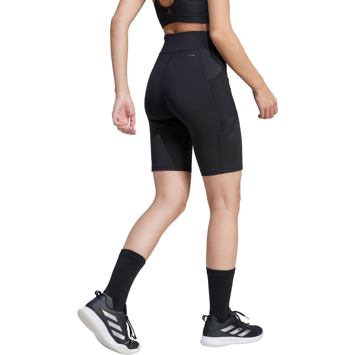 Achteraanzicht van model in de zwarte Adidas Match Short Tight tot boven de knie