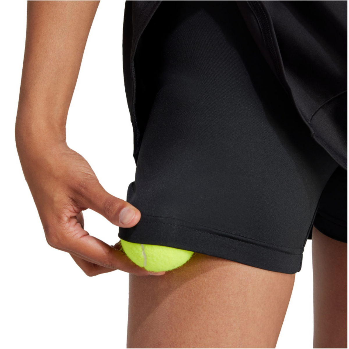 Model pakt een bal uit de binnenbroek onder de zwarte Adidas Match rok