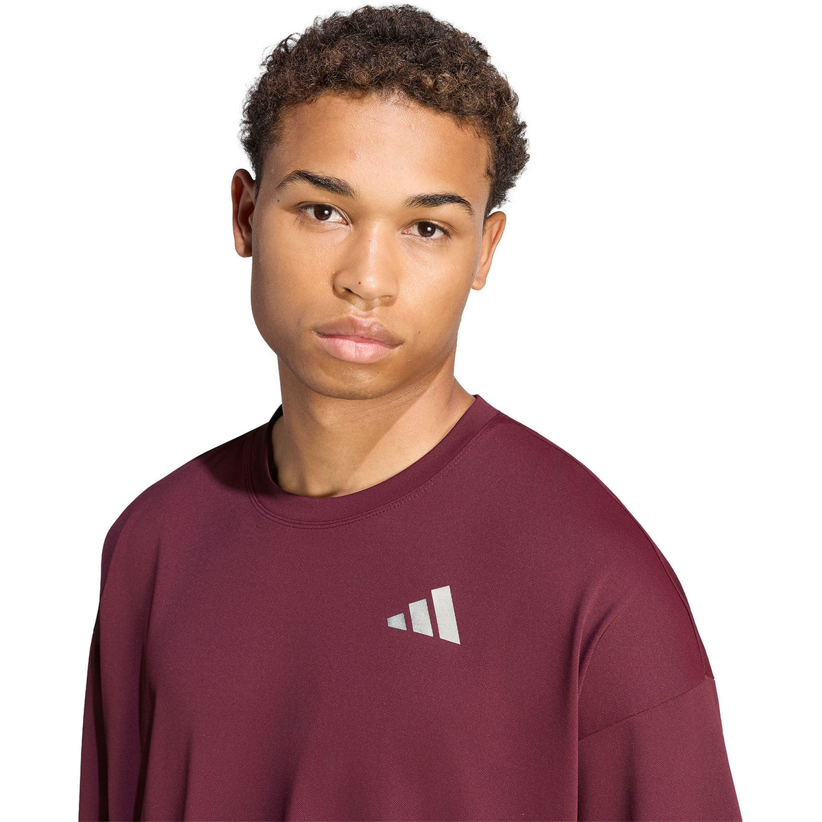 Model van dichtbij in het bordeauxrode T-shirt met zilverkleurig logo