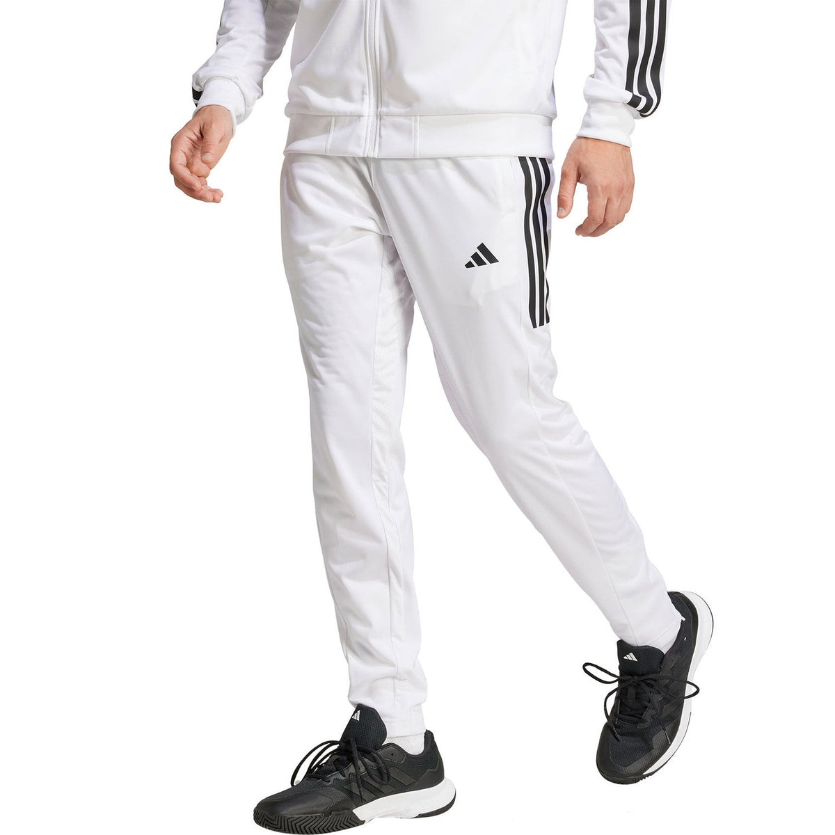 Model draagt de witte Adidas 3-Stripes gebreide trainingsbroek met bijpassend jack