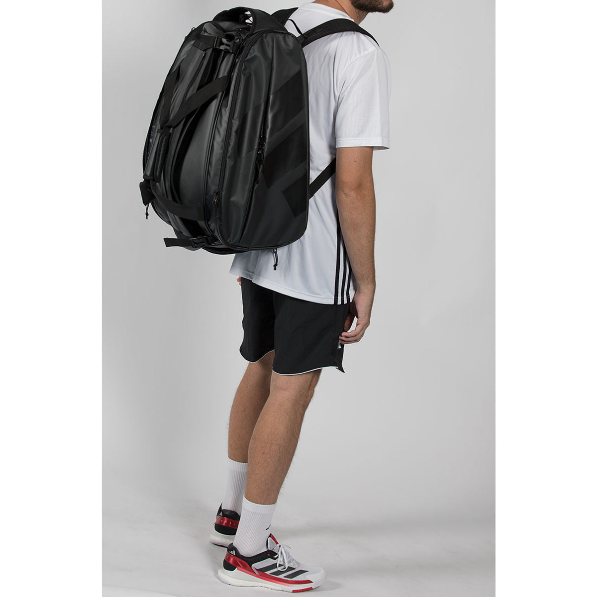 Man van achteren met de zwarte Adidas Racket Bag Multigame 2026 op beide schouders.