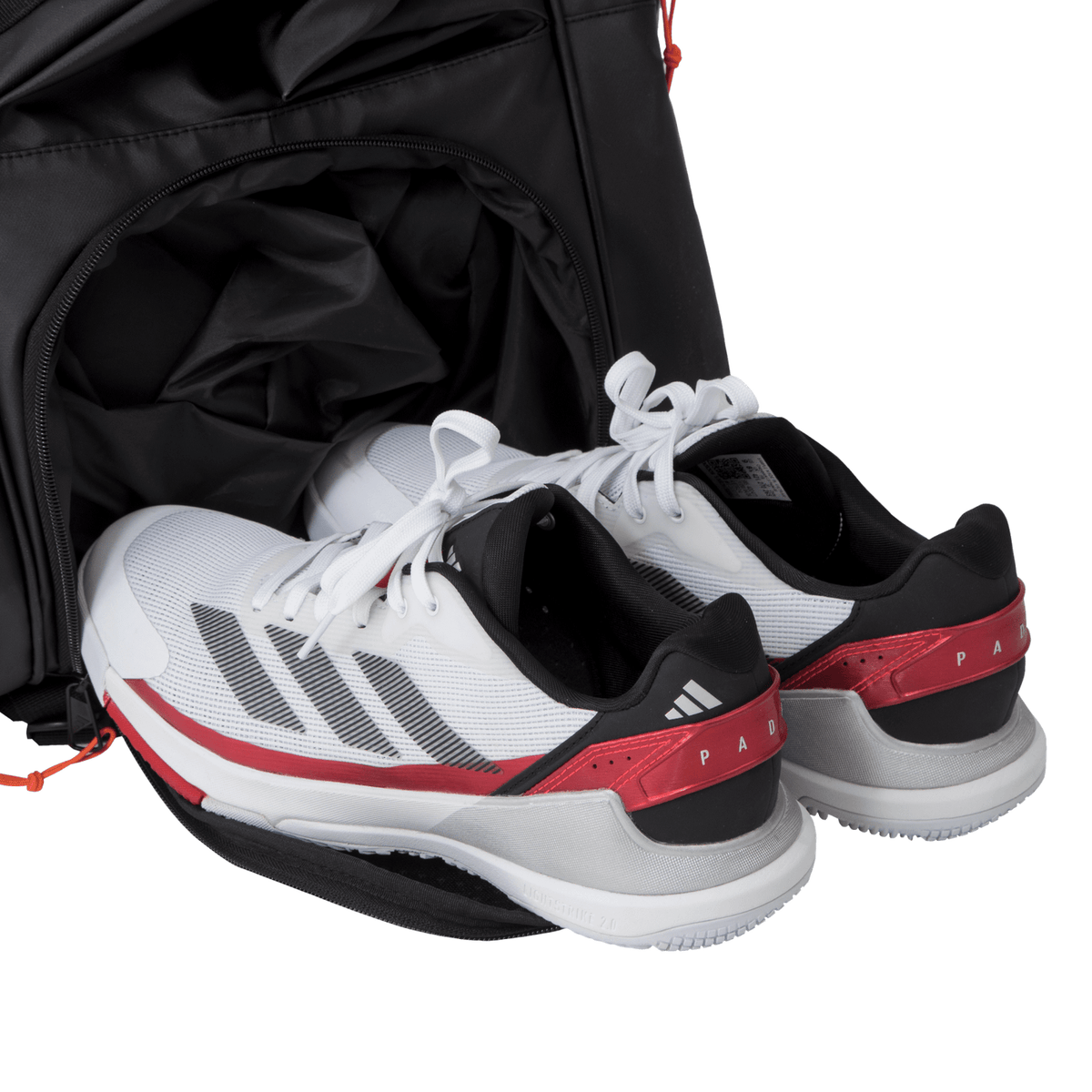 Witte Adidas sportschoenen in het aparte schoenenvak van de Multigame 3.4 racketbag.