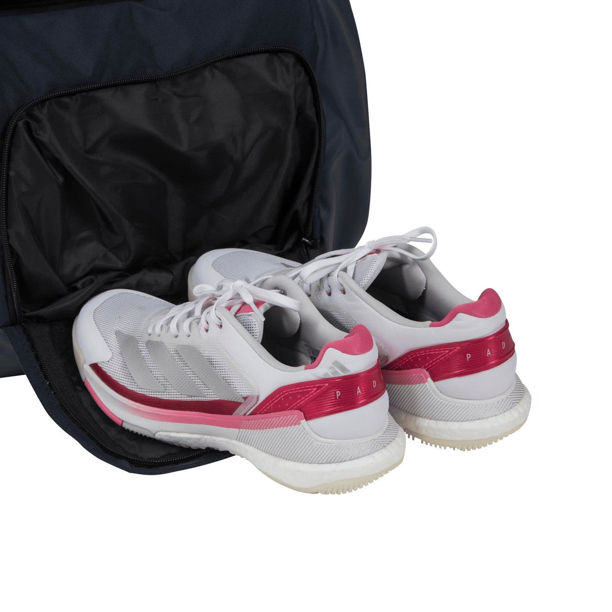 Wit-roze sportschoenen in het schoenenvak van de donkerblauwe Adidas Tour 3.4.