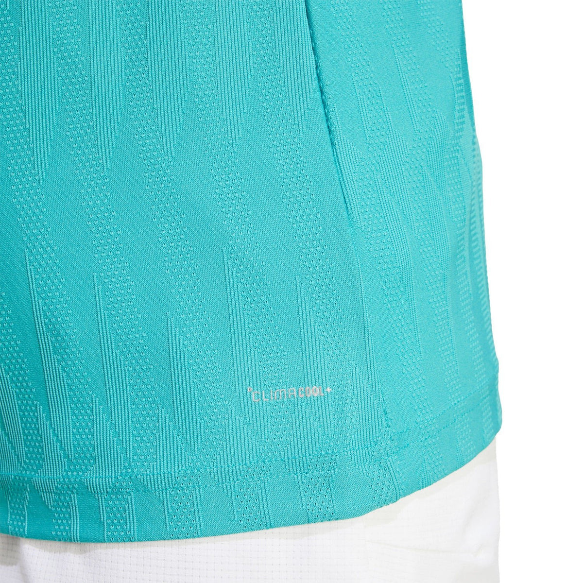 Detail van de zoom en structuurstof van het turquoise Adidas Freelift T-shirt