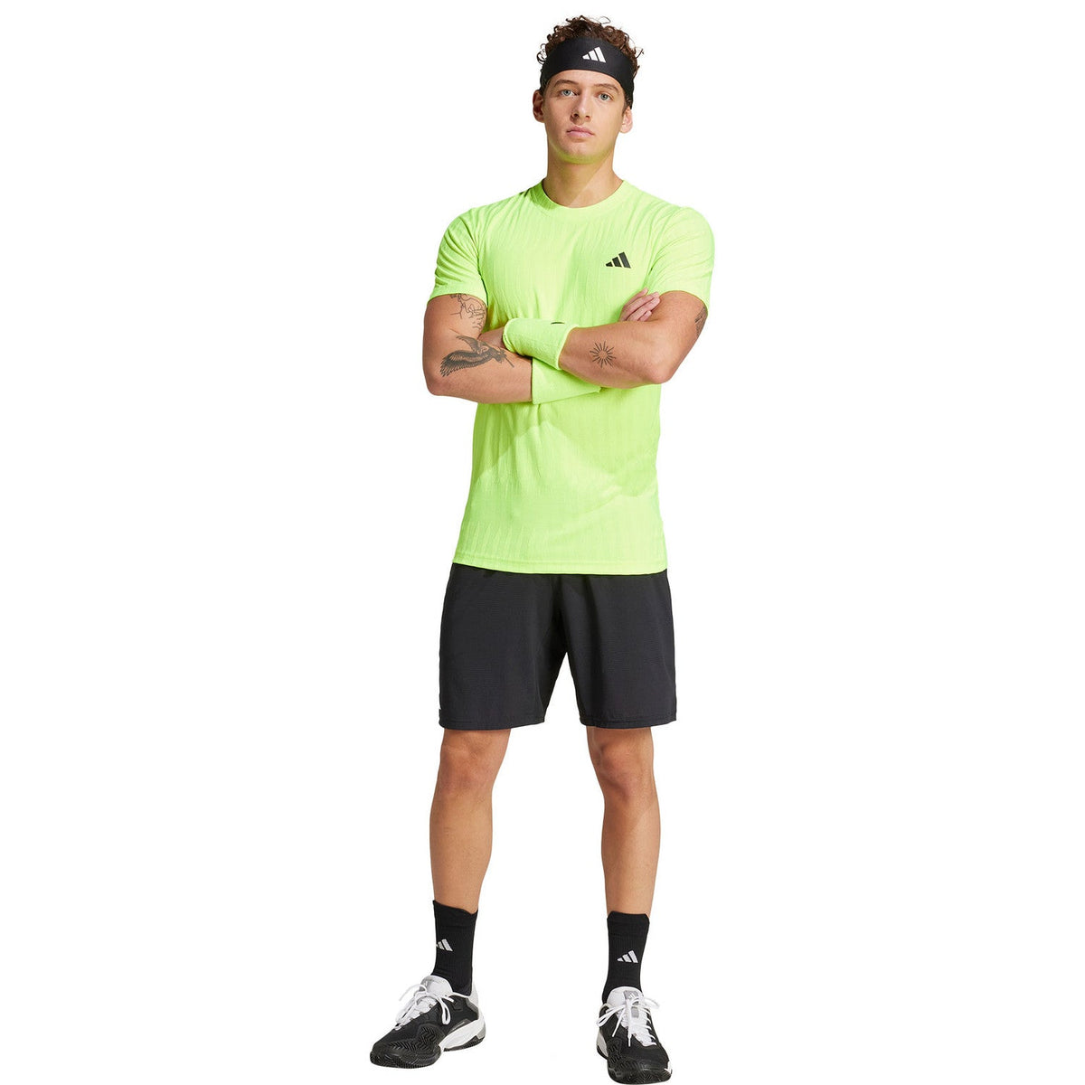 Model draagt het limoengroene Adidas Freelift T-shirt met zwarte short