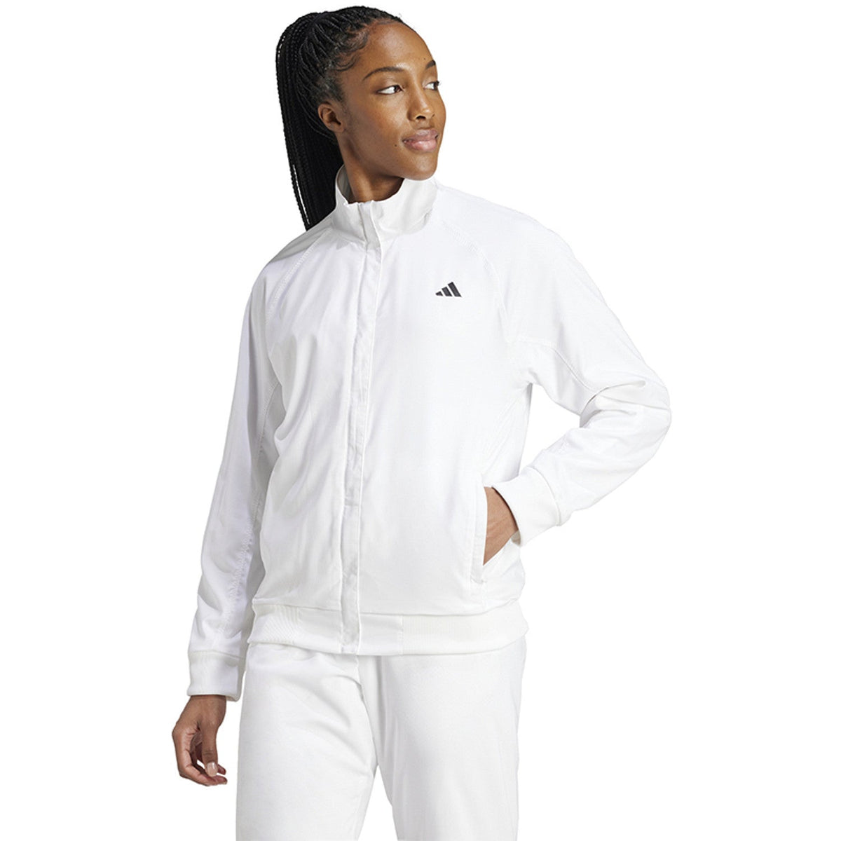Model draagt het witte Adidas Walk On dames jack met hand in de zak en witte broek