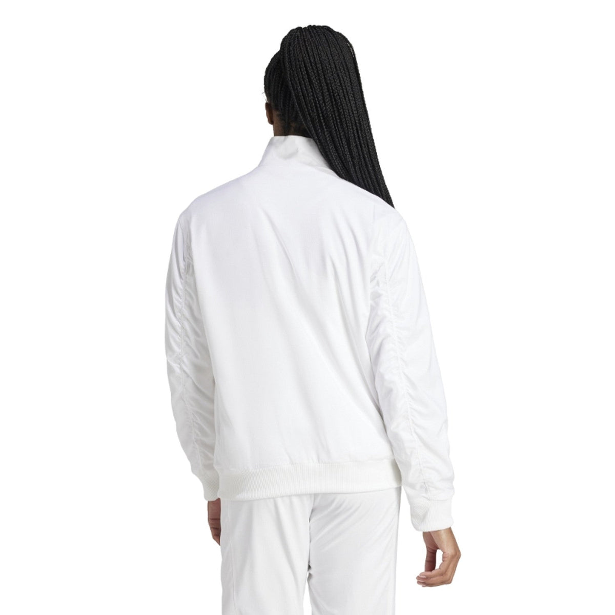 Achteraanzicht van model in het witte Adidas Walk On dames jack met witte broek
