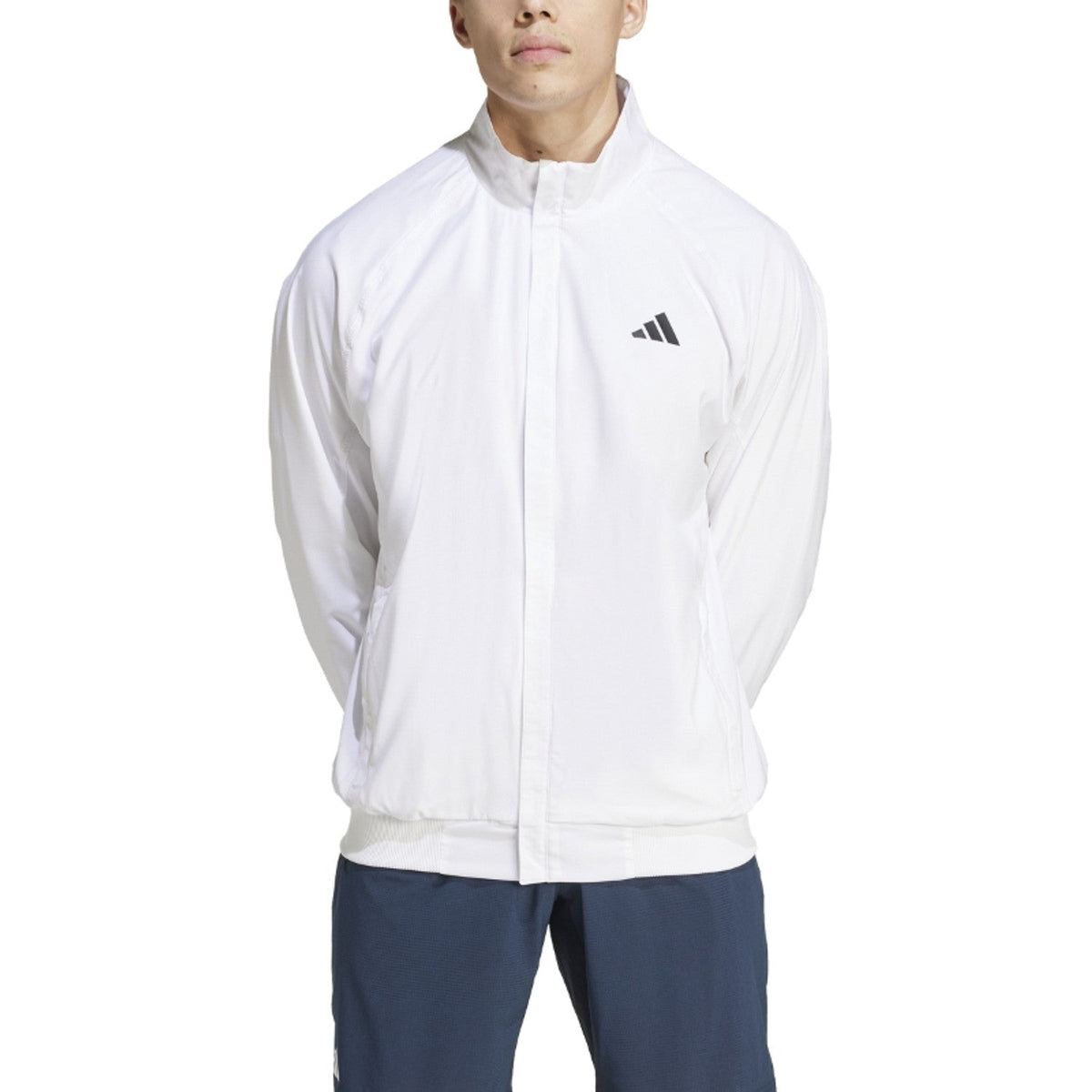Wit Adidas Walk On trainingsjack gedragen met donkerblauwe broek