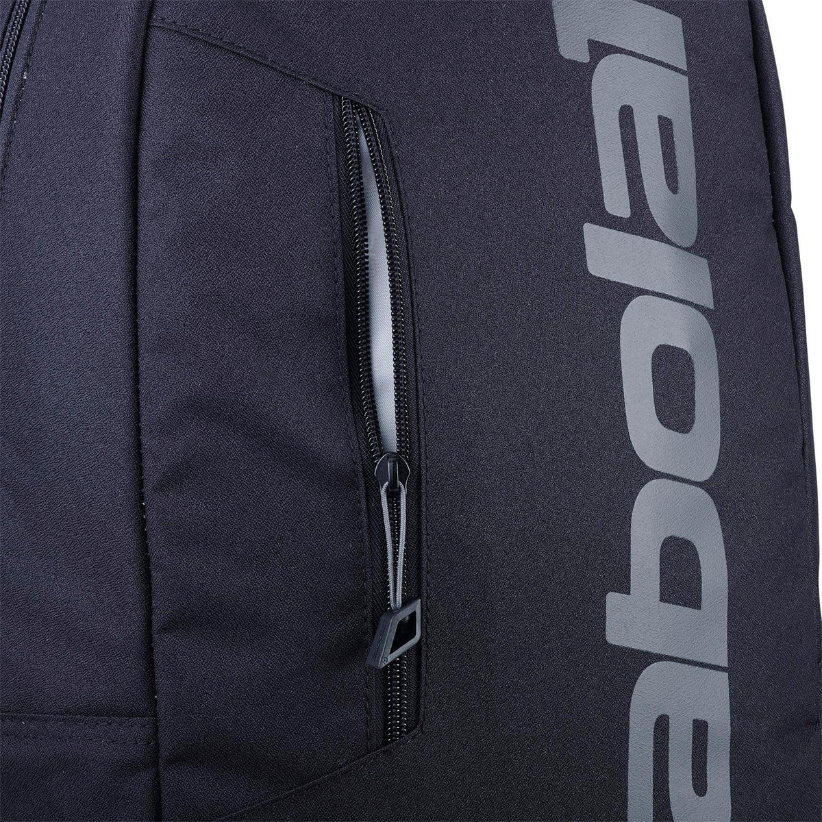 Detail van het ritsvak van de zwarte Babolat Court Lite rugzak met grijze merknaam.