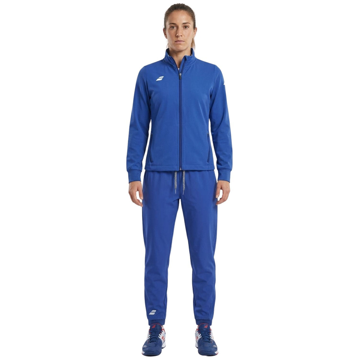 Model draagt het Babolat Play trainingspak voor dames in blauw met jack en broek