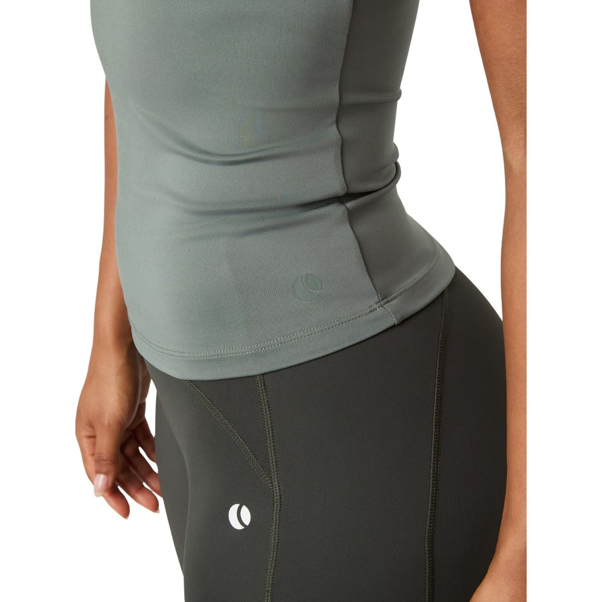 Detail van de zoom van de grijsgroene Bjorn Borg Ace tanktop over de donkere fietsbroek