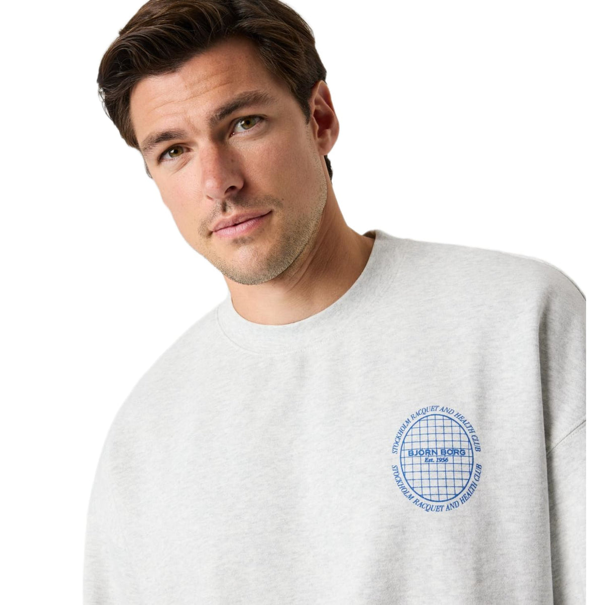 Close-up van de blauwe ronde logoprint op het lichtgrijze Bjorn Borg Ace sweatshirt