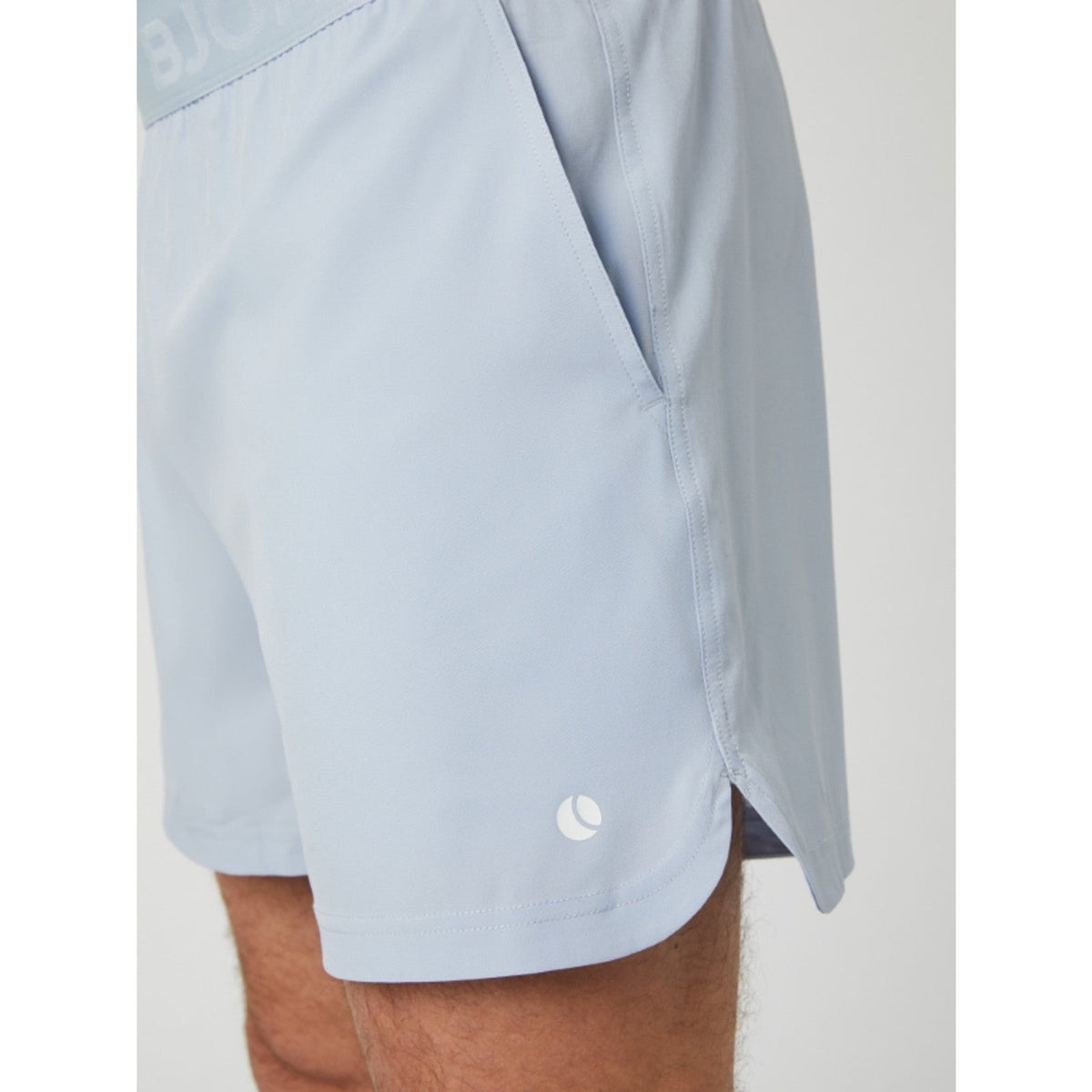 Vue de profil du short Bjorn Borg Ace bleu clair avec fente au niveau de la jambe