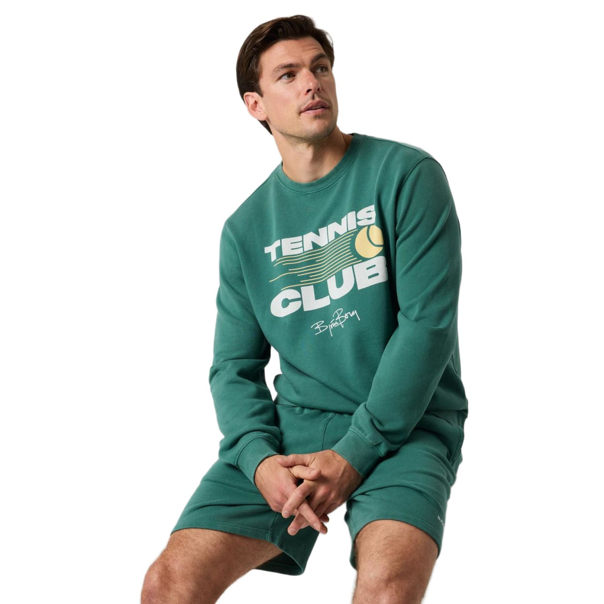 Model zit in het donkergroene Bjorn Borg Tennis Club sweatshirt met groene korte broek