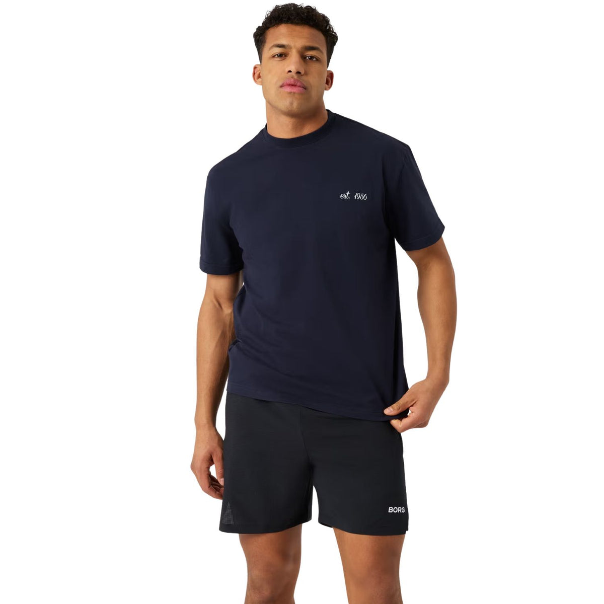 Herenmodel draagt het donkerblauwe Bjorn Borg Classic Print T-shirt met zwarte sportshort