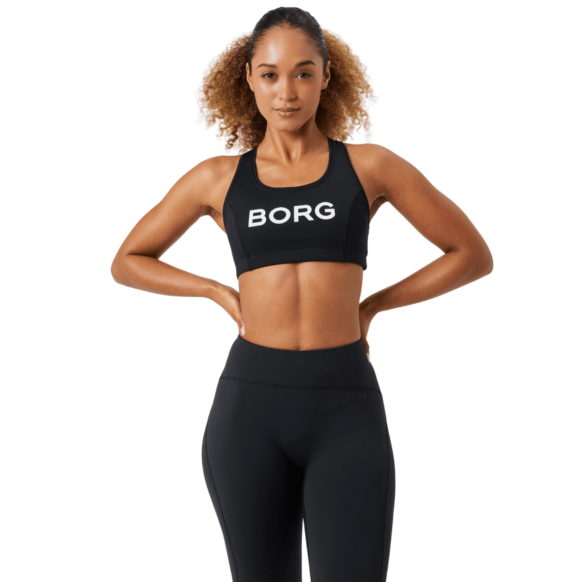 Damesmodel draagt de zwarte Bjorn Borg Mid Support Sports Bra met zwarte legging