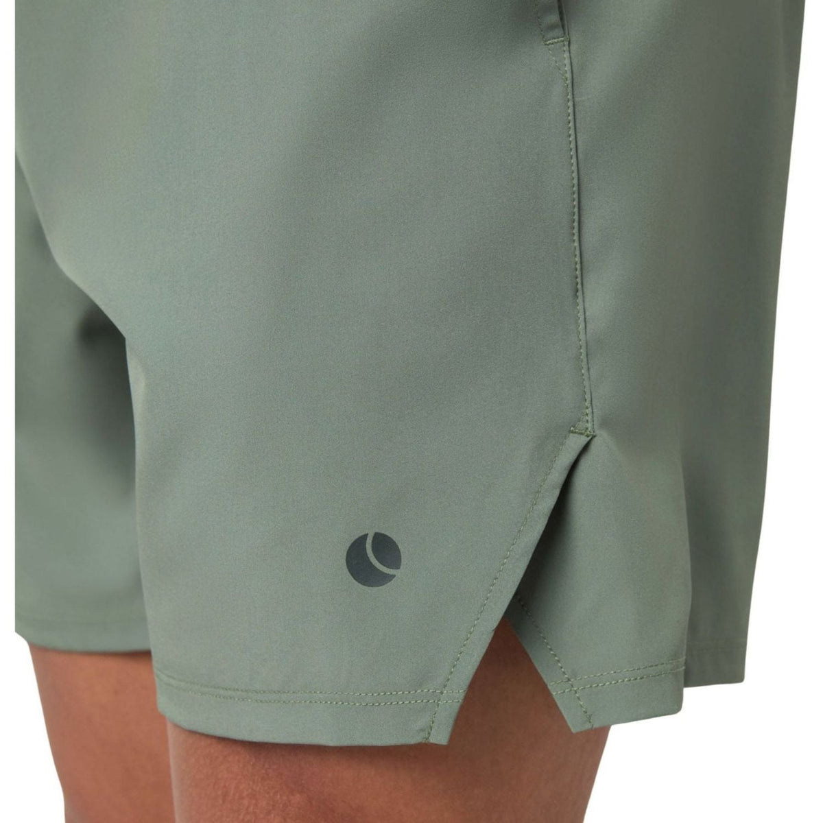 Close-up van de zijsplit en het logo op de saliegroene Short Ace Racquet sportshort