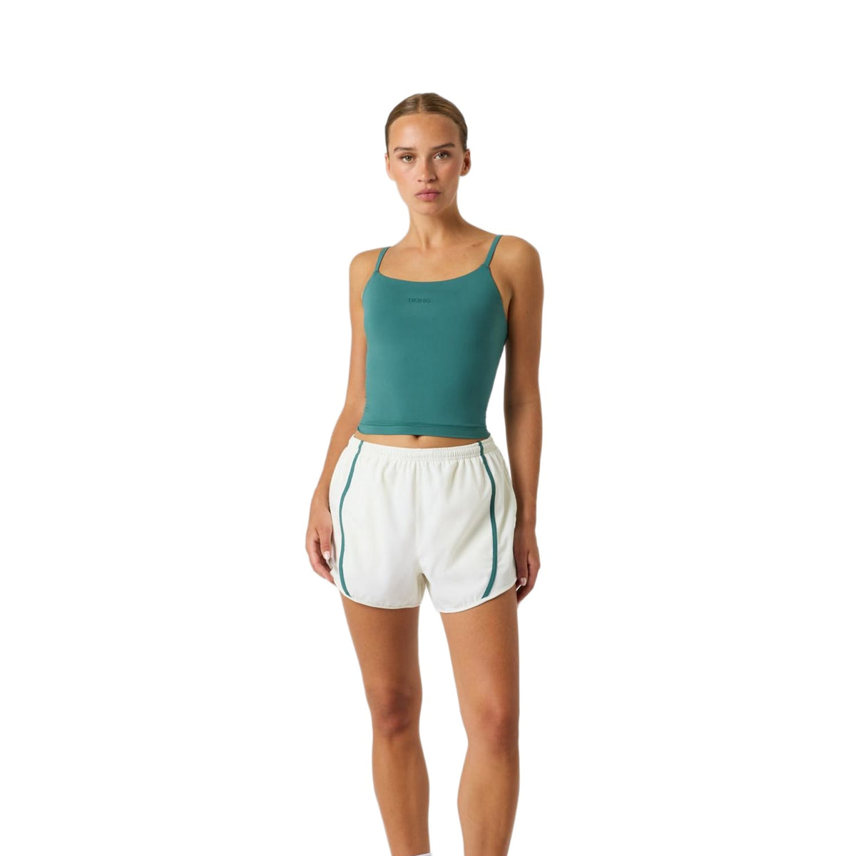 Model ten voeten uit in de gebroken witte Bjorn Borg Sports Shorts met groene tanktop