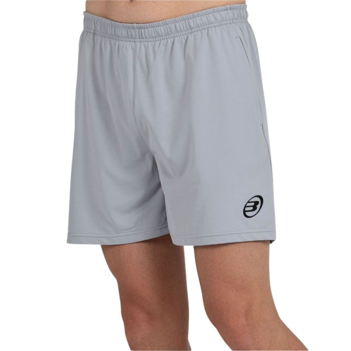 Model draagt de grijze Bullpadel Short Monfort met zwart Bullpadel-logo vooraan
