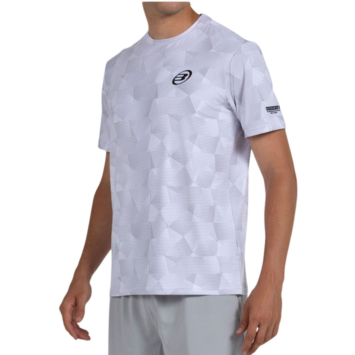 Schuin aanzicht van het witte Bullpadel T-Shirt Macondo met merkband op de mouw