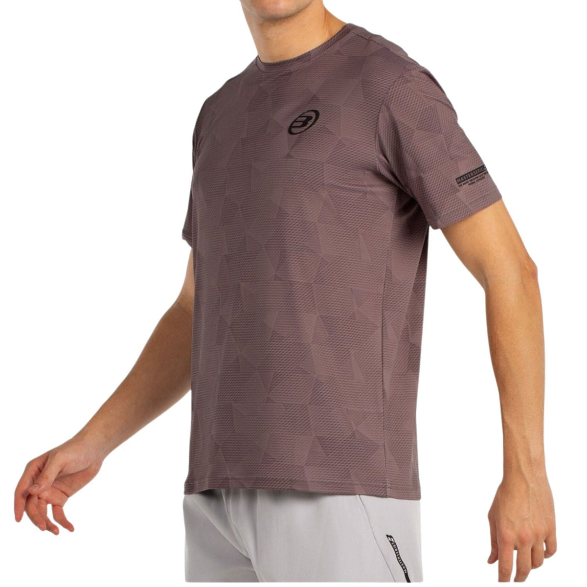 Schuin aanzicht van het bruinpaarse Bullpadel T-Shirt Macondo met merkband op de mouw
