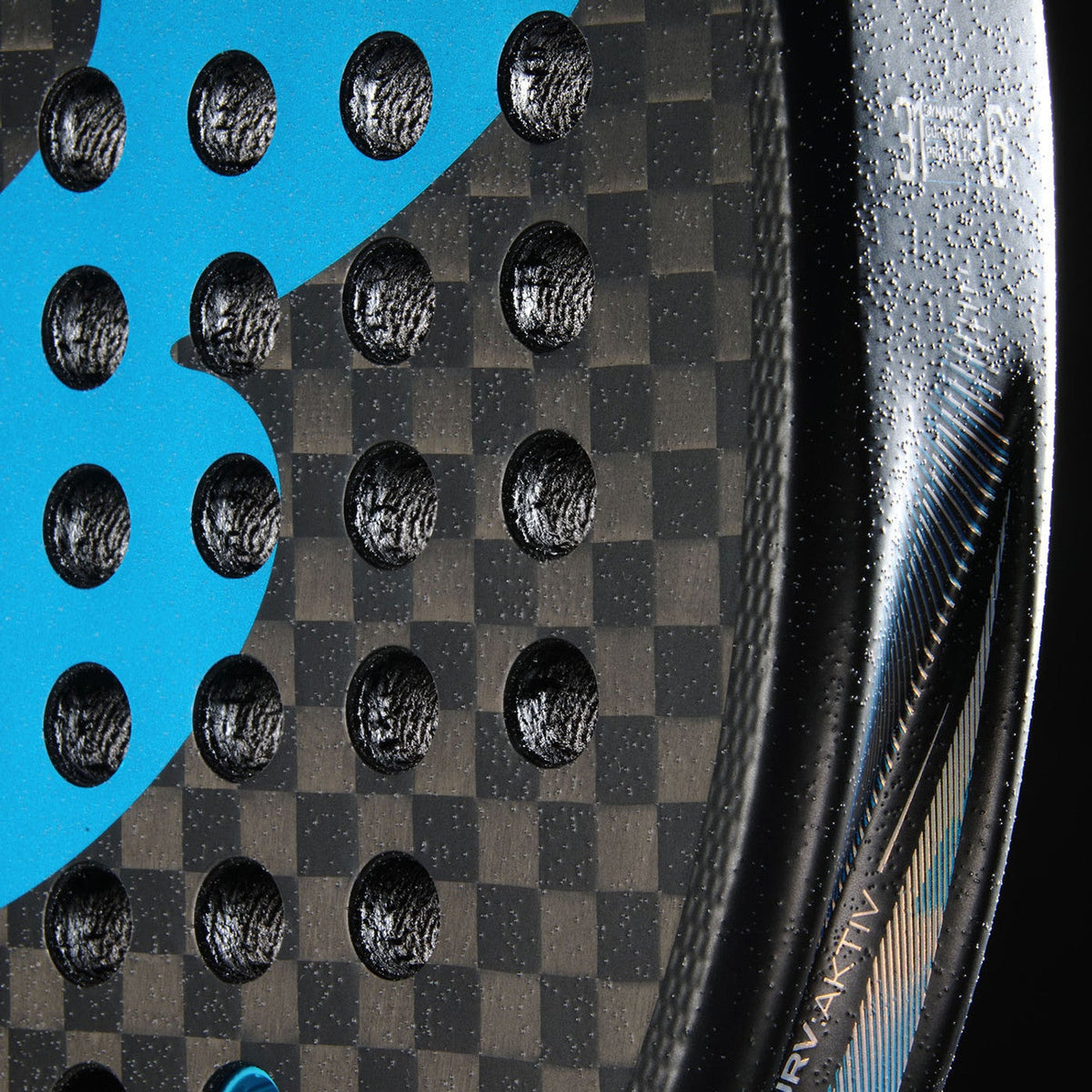Close-up van het ruwe slagvlak van het Bullpadel Vertex 05 Hybrid 26 met carbonweefsel