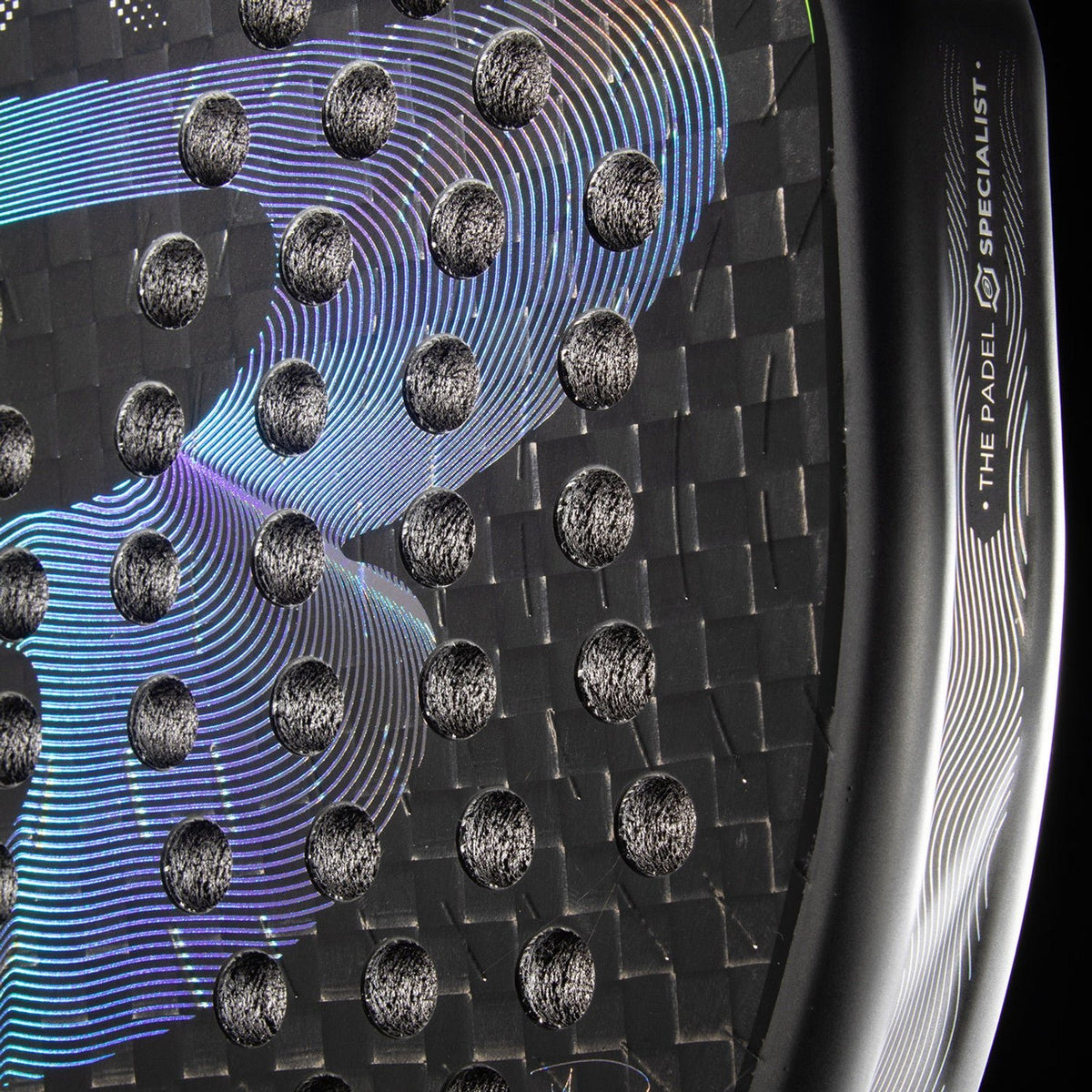 Close-up van het carbonweefsel van het Bullpadel XPLO 26 met paarsblauwe glans