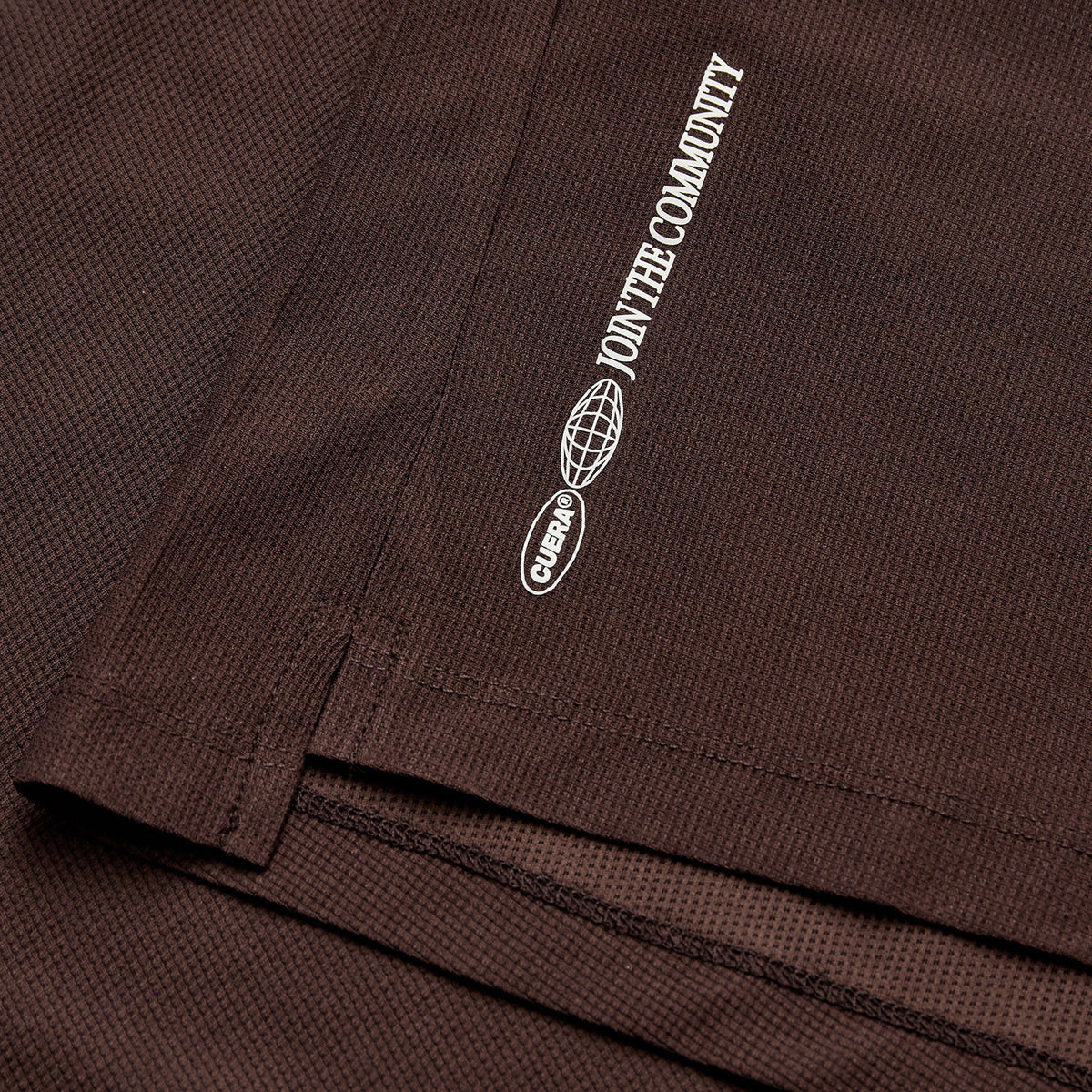 Detail van de zoom met opdruk van het donkerbruine Cuera Breathe T-shirt