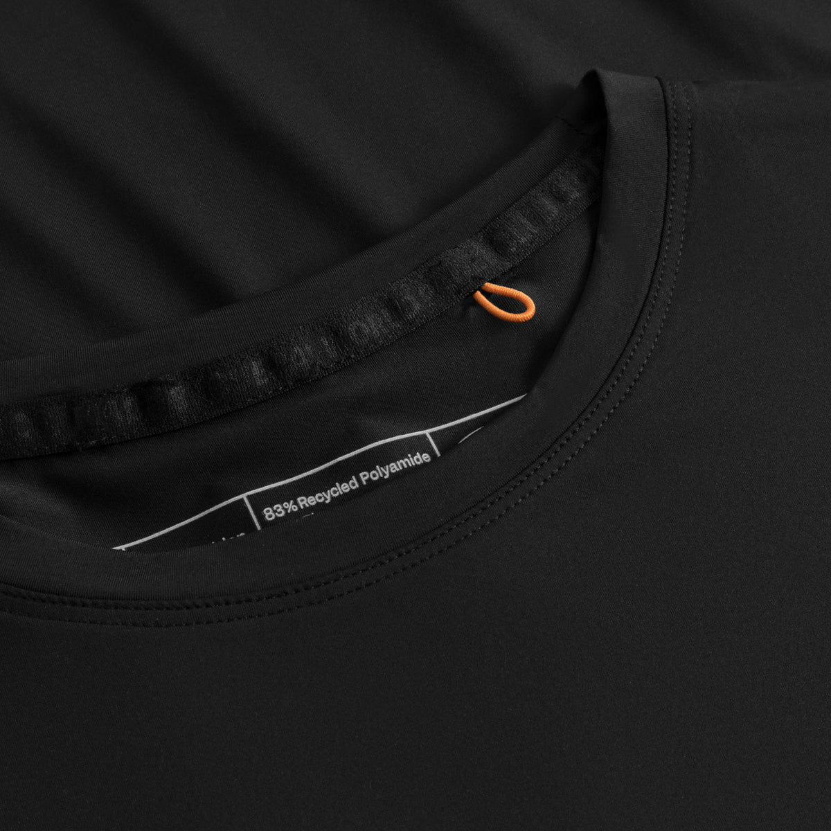 Detail van de halsboord en het label aan de binnenkant van het zwarte Cuera T-shirt