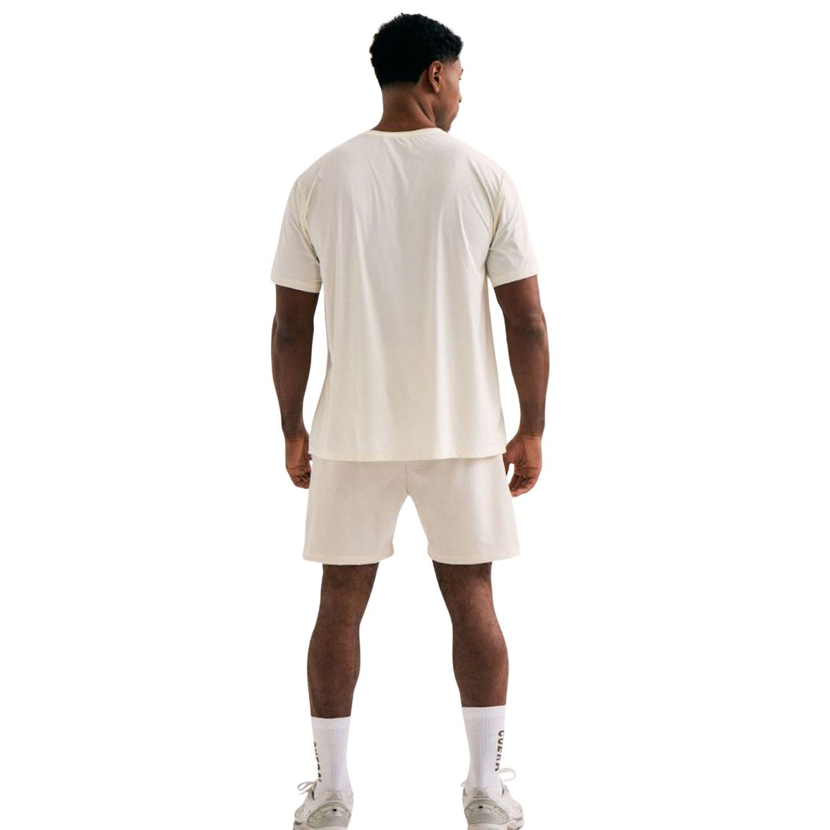 Achteraanzicht van een model in het gebroken witte Cuera WPC T-shirt en short