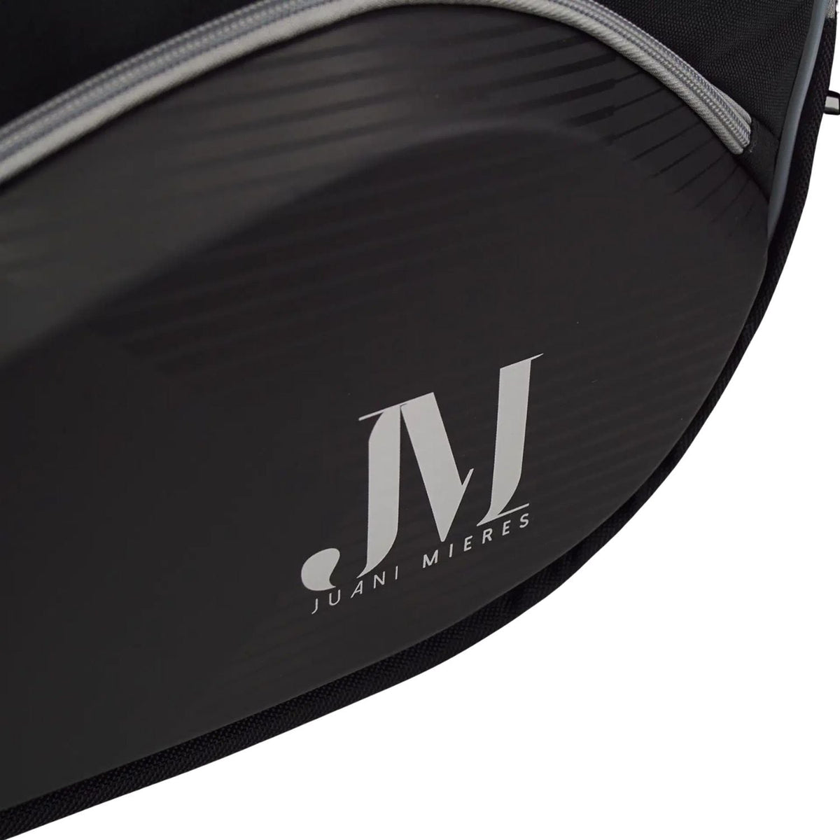 Close-up van het witte JM-logo van Juan Mieres op de zwarte Dunlop Elite padeltas