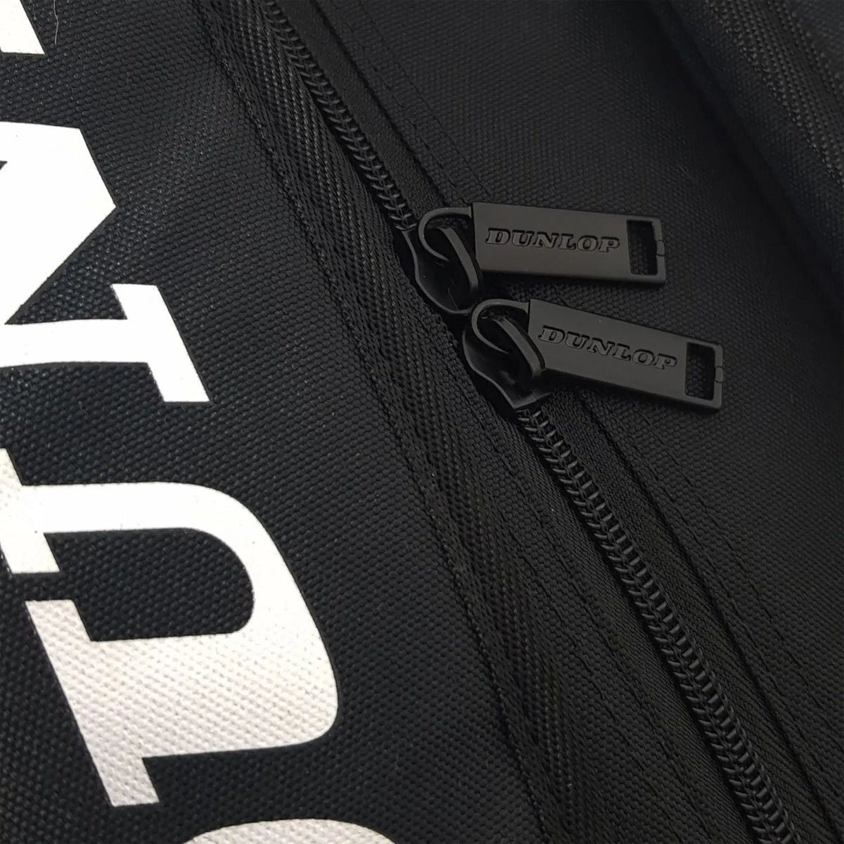 Detail van twee zwarte ritstrekkers met Dunlop-opdruk op de zwarte Elite padeltas