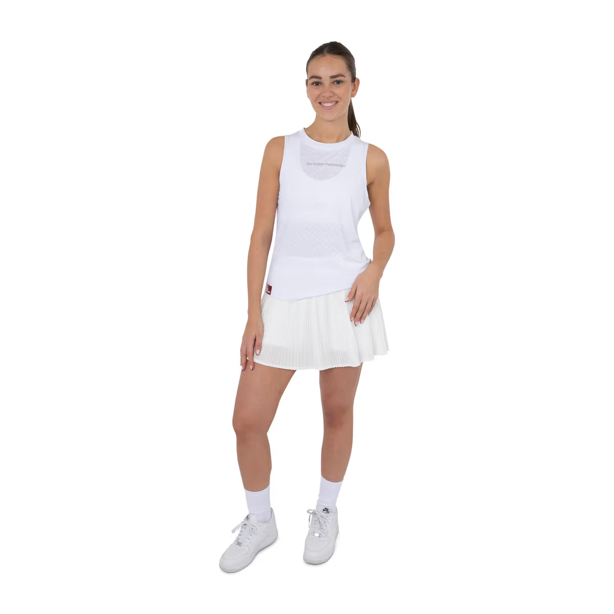Model draagt de witte mouwloze top met witte tennisrok