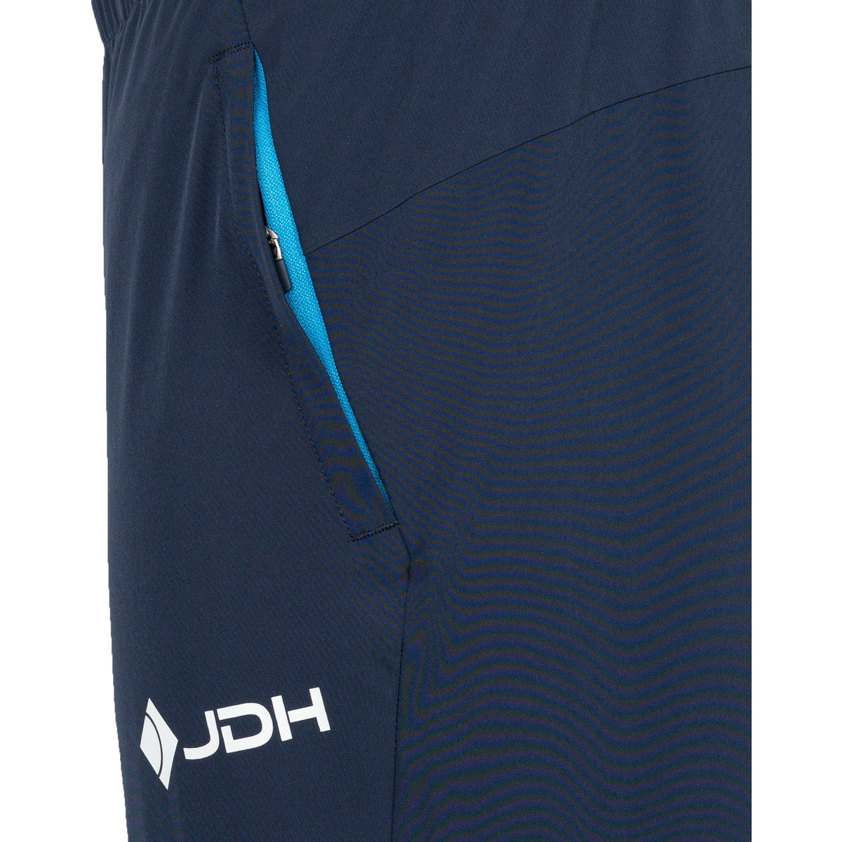Detail van de blauwe ritszak en het witte logo op de donkerblauwe Carbon Pro Light broek