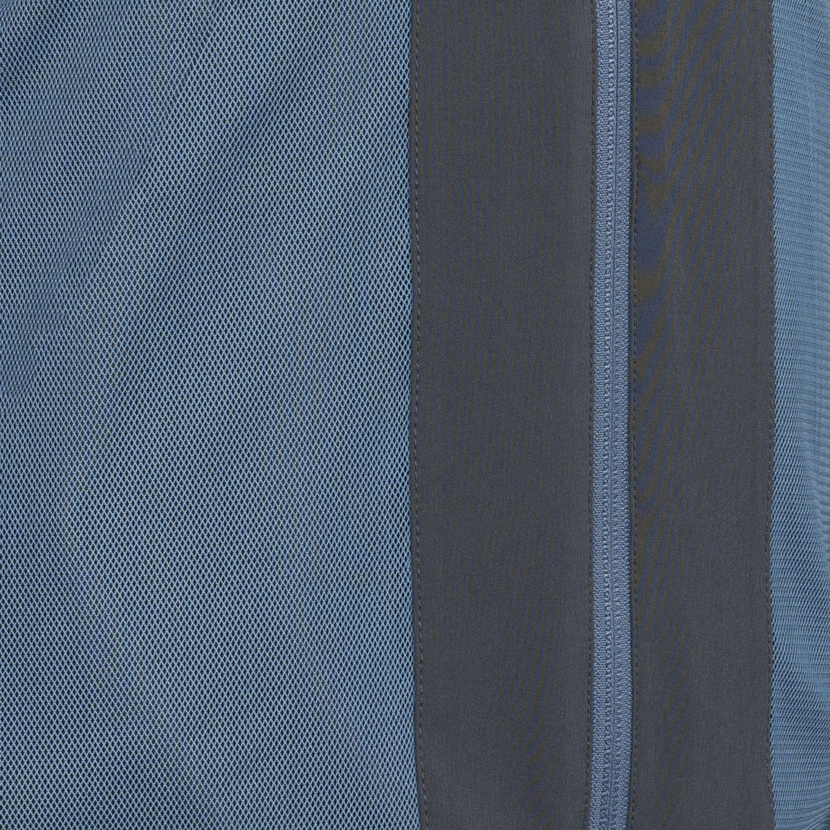 Close-up van de blauwe en grijze stofpanelen langs de rits van het Carbon Pro Light jack